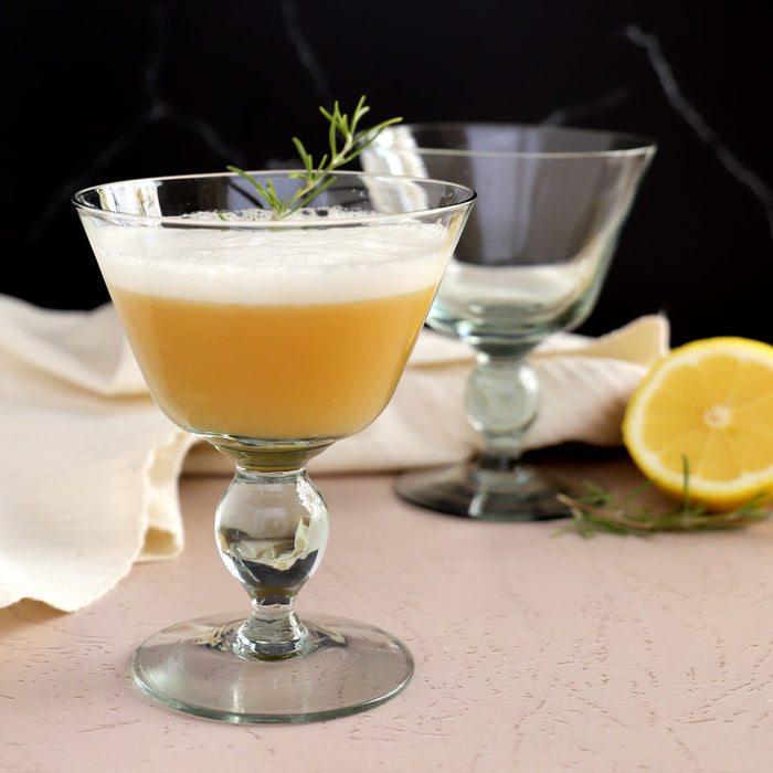 Whiskey sour cocktail recipe with egg white, in recycled glass coupe glasses
