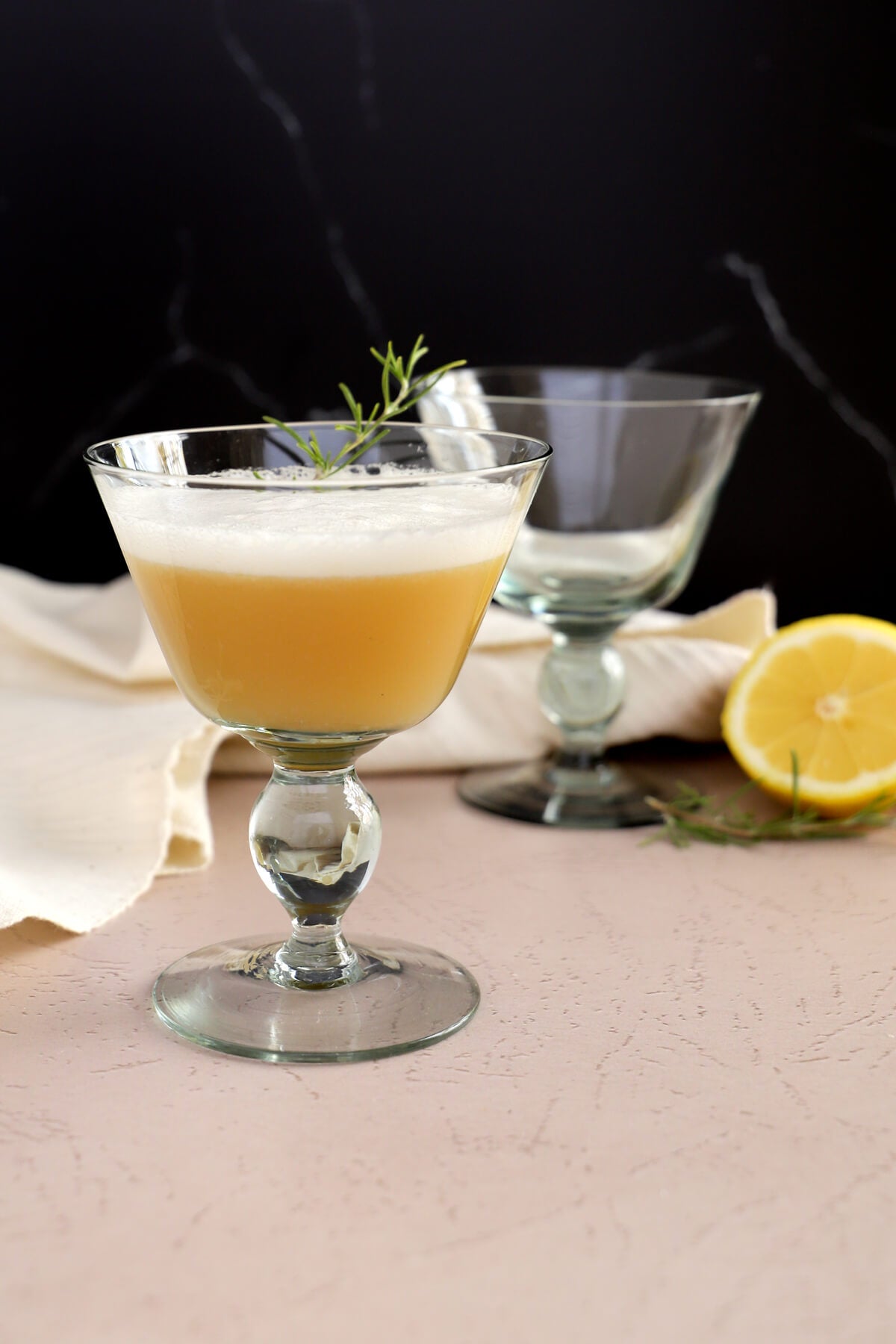 Whiskey sour cocktail recipe with egg white, in recycled glass coupe glasses