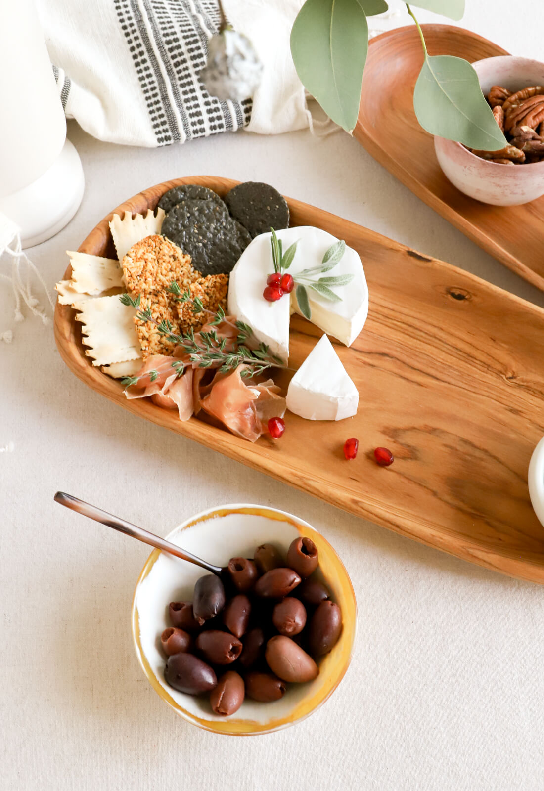 Snack serving bowl made out of cowhorn, styled on a dining room table next to a charcuterie board.