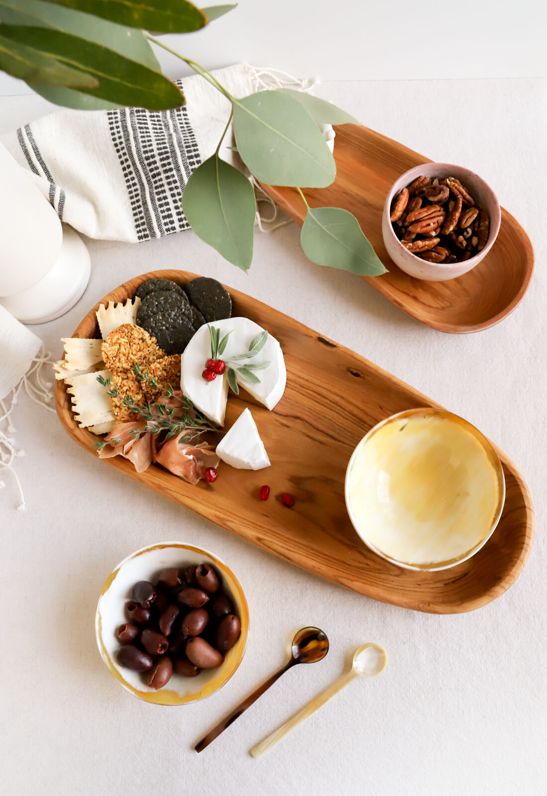 Dining room table showing a Ugandan cowhorn serving bowl, tiny spoons, and a cheese board 
