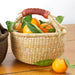 Tan bolga basket, made in Ghana. Shown holding clementines. 