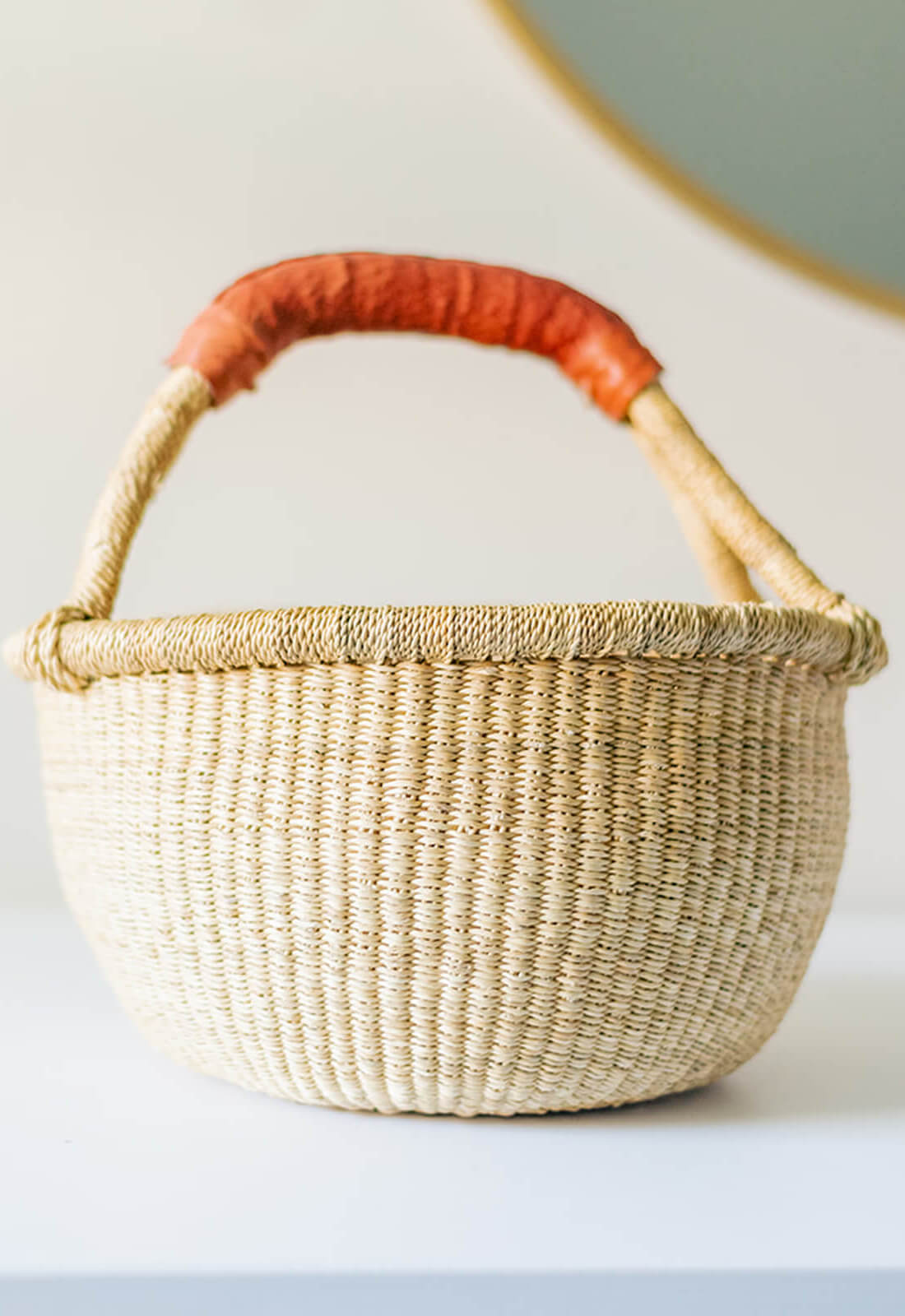 Mini bolga basket, made in Ghana. Shown in a bedroom used as storage.