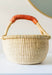 Mini bolga basket, made in Ghana. Shown in a bedroom used as storage.