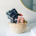 Extra small bolga basket, shown in a nursery being used as storage for baby items. 