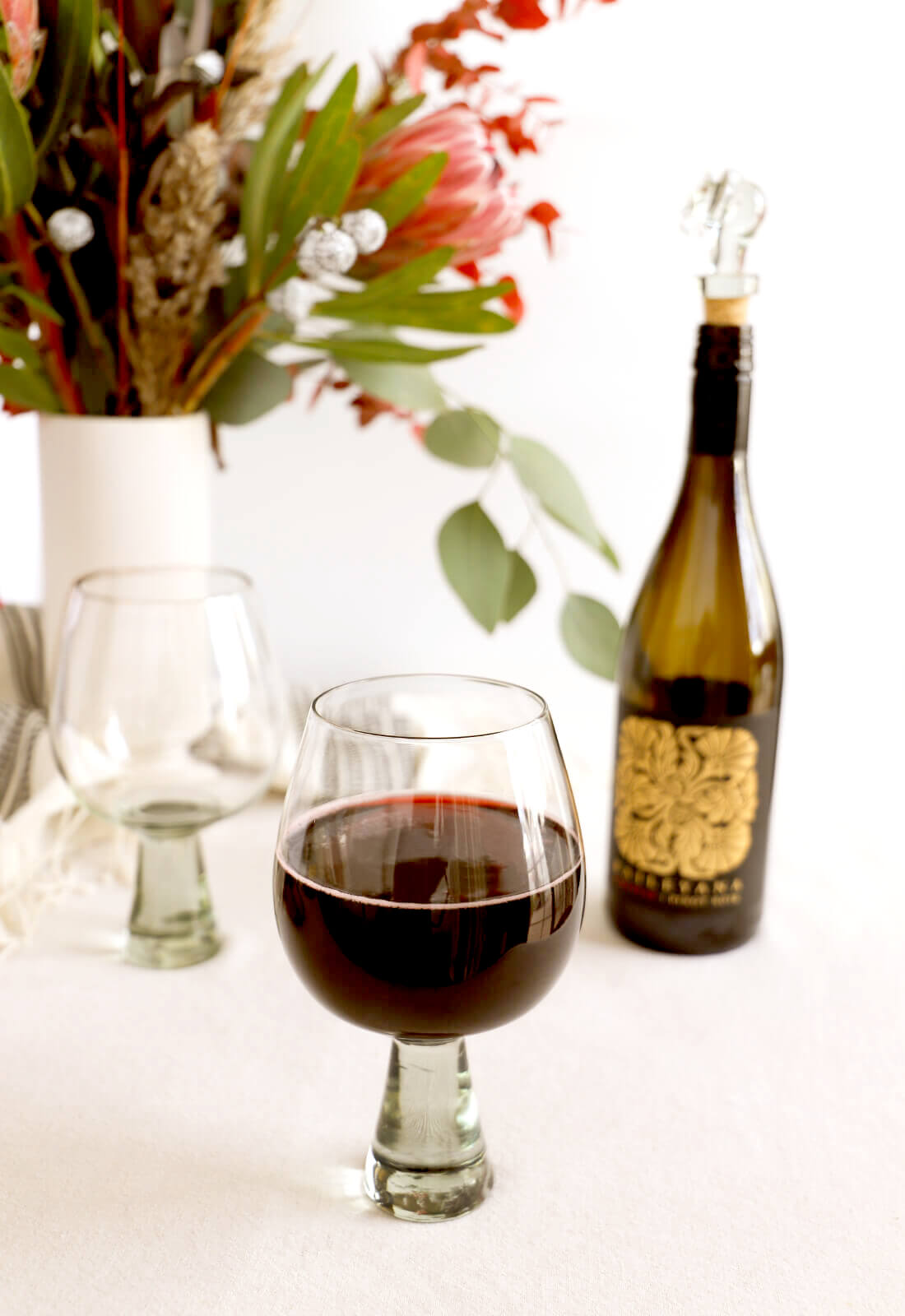 Ngwenya Glass oversized Copa drinking glass, shown with red wine on a dining room table