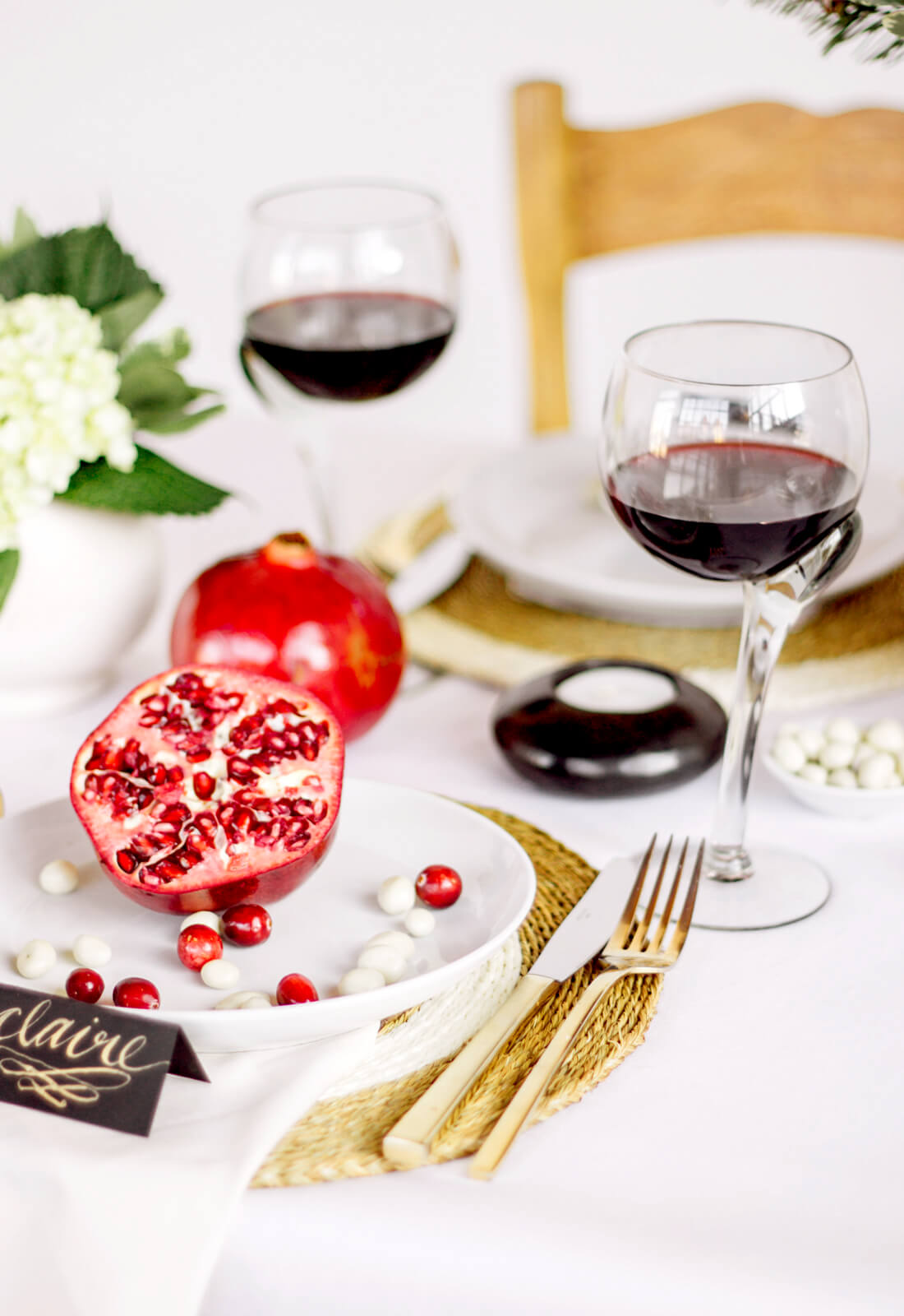 Crooked wine glasses, filled with red wine, styled on a Holiday table