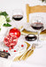 Crooked wine glasses, filled with red wine, styled on a Holiday table