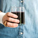 Woman holding a 6 ounce Moroccan glass drinking glass filled with wine 