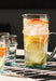 Curved glass jug with handle, shown with citrus water. Made in Morocco. 